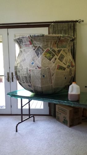 See photo:We are building a cauldron (the milk gallon is for scale).  It has the cardboard frame, shrink wrapped, and mache' to form it.  Which brings us to the monster mud part (this weekend).The question is...  How many layers of MM and cheesecloth do you think this beast will need to be solid enough to play with?  We don't intend it to actually hold water or anything daft like that, but we would like to keep it around for several years of cauldron witching business.We w Paper Mache Witch Cauldron, Diy Paper Mache Halloween Decorations, Giant Cauldron Diy, Paper Mache Cauldron, Halloween Cardboard Decorations, Cardboard Halloween Decorations, Paper Mache Halloween Decorations, Cardboard Halloween Decorations Diy, Paper Mache Halloween