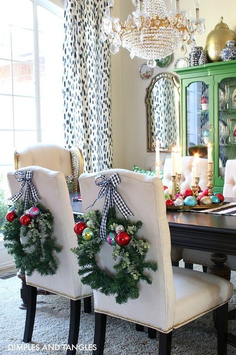 Christmas Chair Wreaths, Chair Christmas Decorations, Decorating Chairs For Christmas, Wreaths On Back Of Chairs, Christmas Wreaths On Chair Backs, Christmas Dining Chair Decor, Wreath On Chair Back, Chair Wreaths Christmas Decor, Wreaths On Chairs