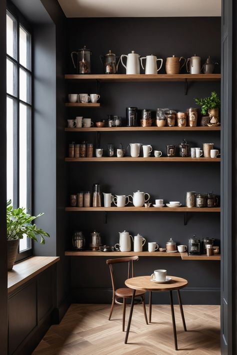 Shelves filled with various coffee and tea pots, mugs, and jars in a cozy corner with natural light and a small table with a cup. Modern Coffee Shop Aesthetic, Modern Coffee Bar Design, Cafe Shelving, Coffee Shelves, Coffee Nook Ideas, Coffee Nooks, Inspirational Kitchens, Nook Inspiration, Tea Corner