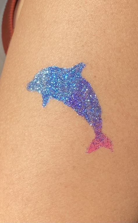 dolphin glitter tattoo on with blue purple and pink glitter Glitter Tattoo Summer, Coconut Girl Drawing, Coconut Girl Tattoo, Glimmer Tattoo, Glitter Tatoos, Glitter Tattoo Ideas, Glitter Henna, Yellow Ladybug, No Ordinary Girl