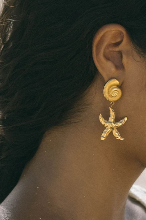 From the beach to the terrace, we can't get enough of the Bali Earrings. These seaside-inspired studs showcase a detailed seashell paired with a unique starfish pendant. Whether you're by the ocean or not, they bring a touch of summer magic to any outfit. Pair it with our Bali Necklace for a complete coastal look. Summer Magic, Bali Earrings, Starfish Pendant, By The Ocean, The Terrace, Starfish, The Ocean, Terrace, Bali