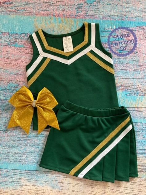 Cute girls cheerleading uniform!  Great for spirit days, pep rallies and sporting events!  This can be customized for your team and is available in multiple color selections.   Set included skirt and shell & mascot embroidered across the front. Bow is sold separately here: https://www.etsy.com/listing/1709445496/bulldogs-bow-black-gold-bulldogs-bow?click_key=916bd370755ac7b85ceaca90468eb28f98567936%3A1709445496&click_sum=1b5c64d2&ga_search_query=bow&ref=shop_items_search_5&sts=1 Uniform Color: Hunter Green with metallic gold/white trim Need something custom?  Message me with your requests! Spirit Days, Sports Uniform, Cheer Uniforms, Cute Cheerleaders, Cheerleader Costume, Cheerleading Uniforms, Football Uniform, Cheer Uniform, Cheer Girl