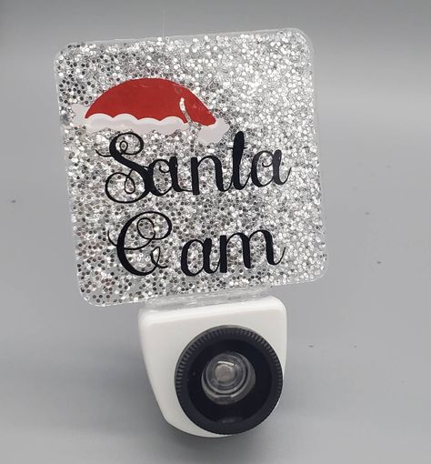 You better watch out, Better not pout, Better not cry,  I'm telling you why.... Santa Cam will keep everyone on the nice list! NOT a real camera Glows blue when plugged in Indoor use only Caution: This item is NOT a toy Plug only into exposed wall outlets where device is well ventilated Do NOT use with extension cords Night Light Cricut Ideas, Santa Cam Nightlight Diy, Christmas Night Light Diy, Dollar Tree Night Light Ideas, Cricut Christmas Projects To Sell, Santa Cam Night Light, Christmas Cricut Projects To Sell, Cricut Crafts To Sell, Night Light Ideas