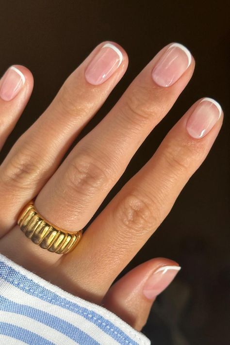 Timeless elegance shines through on these squoval-shaped nails, adorned with a classic French tip. The combination of a natural pink base and perfectly rounded, crisp white tips exudes sophistication and cleanliness, making it a versatile choice for any event. Embrace understated chic with this classic French manicure. // Photo Credit: Instagram @saskiafenwick Natural Color French Tip, Small Tip French Manicure, Nails Shellac French Tip, Short Elegant Gel Nails, Short Squoval Nails French Tip, Small French Manicure, Manicure Shapes Short Nails, Square Oval Short Nails, French Tip Gel Manicure Short