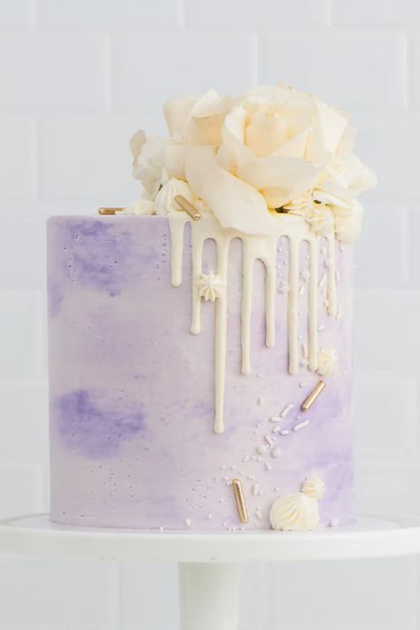 Bring luxury to your dessert with our elegant ombre Lavender Dolce Flor Cake. Fresh white florals sit atop a divine white chocolate drip, tinted vanilla frosting, and a hint of deluxe sprinkle. Choose from any of our decadent cake flavors so this cake is truly made for you. This sleek cake design is picture perfect for so many different occasions including birthdays, baby showers, engagements and any celebration! Greater LA Delivery ONLY