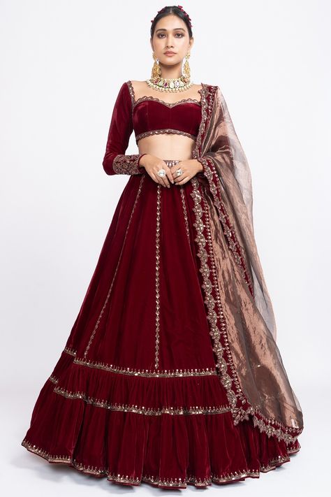 Featuring a red double tiered lehenga in velvet base with rose gold hand embroidery. It is paired with a matching blouse and a tissue dupatta.  FIT: Fitted at bust and waist. COMPOSITION: Velvet, Tissue. CARE: Dry clean only. Maroon Blouse Lehenga, Maroon Lehenga For Bridesmaid, Maroon Velvet Blouse For Lehenga, Lehanga Designs Full Sleeves, Maroon Full Sleeve Blouse, Velvet Blouse Designs For Lehanga, Velvet Lengha Lehenga Choli, Full Sleeve Lehnga Designs, Full Sleeves Blouse Design For Lehenga