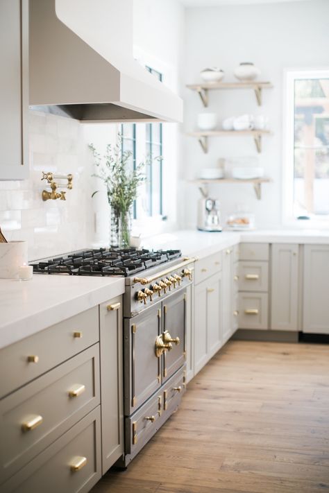 Light green kitchen cabinets with brass handles and a European stove with white marble countertops. Light Grey Kitchen Cabinets, Vintage Style Home Decor, Light Grey Kitchens, Light Gray Cabinets, Vintage Style Home, Light Wood Floors, Bright Kitchens, Home Luxury, 아파트 인테리어