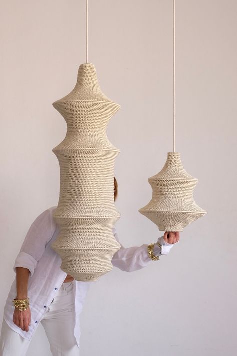 Two handcrafted crochet pendant lights suspended with a woman dressed in all white in the background. Modern Moroccan Design, Lampe Crochet, Crochet Pendant, Crochet Lamp, Affordable Lighting, Lighting Installation, Modern Moroccan, Marrakech Morocco, Handmade Lighting