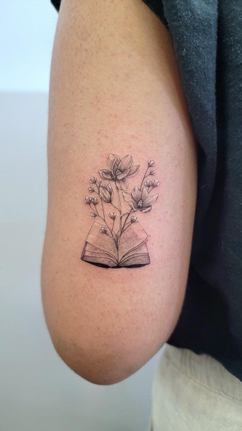 Micro needle work. Book with magnolia flowers and babys breath! Open Book Floral Tattoo, Book With Flowers Coming Out Tattoo, Tattoo Book With Flowers, Book And Wildflower Tattoo, Line Work Book Tattoo, Audio Book Tattoo, Book Micro Tattoo, Rose And Book Tattoo, Tattoo For Teachers Ideas