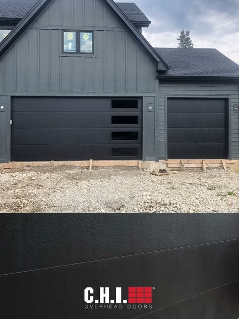 Add moody tones and a sleek, modern look to your home with Skyline Flush by C.H.I. Overhead Doors. Perfect your look by customizing your window and glass designs. Order free color samples, request a quote, or find a C.H.I. dealer today. // via @justinthegaragedoorguy on Instagram for DJK Custom Homes Black Modern Garage Door With Windows, Chi Black Garage Doors, Grey House Black Garage Door, Black Garage Doors With Windows, Gray House Black Garage Door, Black Garage Door With Windows, Houses With Black Garage Doors, Modern Garage Doors With Windows, Modern Black Garage Door