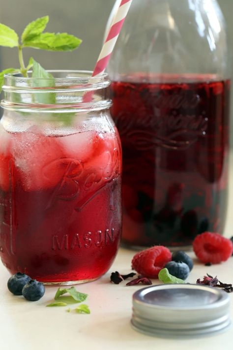 This Hibiscus Tea Recipe (Agua de Jamaica) combines dried hibiscus flowers, a mix of fresh organic berries and water to create a healthy thirst-quenching drink.  Add a drizzle of honey or a splash of lemonade for a delicious tasting Hibiscus Sweet Tea. Iced Tea With Tea Bags, Hibiscus Tea Recipe, Hibiscus Iced Tea, Tea Infusion Recipes, Blueberry Green Tea, Hibiscus Flower Tea, Hibiscus Drink, Berry Hibiscus, Cold Brew Iced Tea