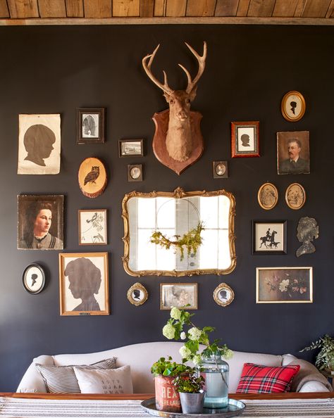 This cabin that mixes eras and textures is rustic, resilient and fits the family just right. Here, matte gray-black paint provides a sophisticated backdrop for a casual mix of framed and unframed family silhouettes, oil paintings, and a 1920s deer mount. Drop Cloth Slipcover, Deer Head Decor, Tennessee Cabins, Different House Styles, Dark Walls, Rustic Cabin Decor, Classic Decor, Deer Head, Spare Room