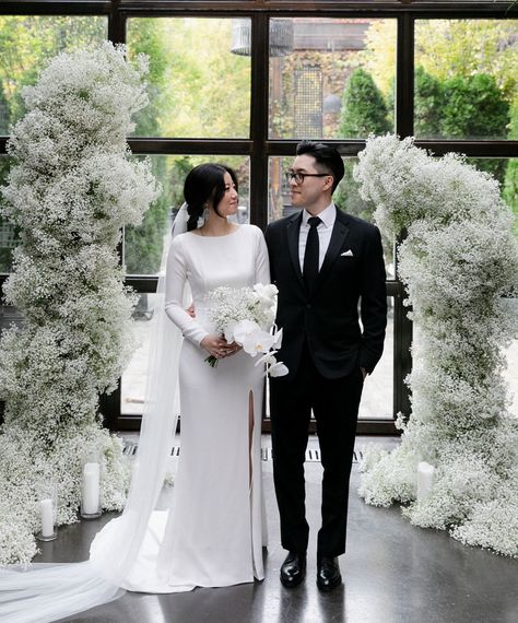 A minimalist wedding in New York City featuring a botanical and modern industrial venue. The ceremony was framed by a cloud of babies breath while the reception table decor featured colorful and modern sculptural floral arrangements of roses and anthurium. We absolutely love the bride's chic crepe dress and overall modern bridal style. #minimalistwedding #newyorkwedding #babiesbreath #modernweddingideas #minimalweddingdecor #gws #greenweddingshoes Gypsophila Wedding, New York Bride, Minimalist Wedding Decor, Ceremony Design, Modern Minimalist Wedding, Ceremony Arch, Mod Wedding, Modern Bridal, Green Wedding Shoes