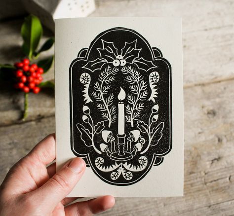 This is a lino printed Christmas card with a candle in the centre and forest inspired plants all around it. The frame gives it an elegant and festive touch. The card is hand printed with black ink and comes with a brown envelope made out of recycled paper. It is also available in a set of three assorted cards - see link bellow. The card is designed to be reused thanks to its blank, removable inner sheet - start a new Christmas tradition by resending this card every year! All greeting cards are d Simple Christmas Lino, Holiday Linocut Prints, Yule Linocut, Linocut Christmas Cards, Lino Christmas Cards, Lino Cut Christmas Cards, Linocut Christmas Cards Ideas, Lino Print Christmas Cards, Christmas Lino Print Ideas