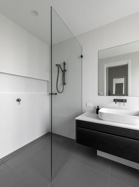 Monochromatic Look with White Shower Wall Tiles for a Contemporary Design Style
The white shower wall tiles and the niche provide simplicity with a monochromatic appeal thanks to the gray floor tiles and the black floating vanity design. White Marble Shower Tile, White Shower Tile Ideas, Shower Wall Tiles, Large White Tiles, White Shower Tile, White Marble Shower, Grey Bathroom Floor, Marble Shower Tile, White Tile Shower