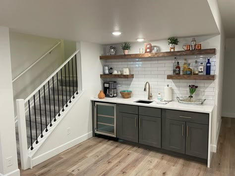 Dry bar or wet bar? Open storage or closed storage? Full-size fridge or mini fridge? All decisions to think about. This mini fridge was included in the basement package and provided by Specialty Appliance. #thebasementsanctuary #basementdesign #basementkitchen #basementbar #basementdesign #rennovation #finishedbasement #modernbasement #arvadacolorado #centennialcolorado Basement Dry Bar Ideas, Basement Bedroom Decor, Basement Style, Basement Living Room Ideas, Small Finished Basements, Basement Bathrooms, Room Ideas Basement, Small Basement Kitchen, Wet Bar Basement