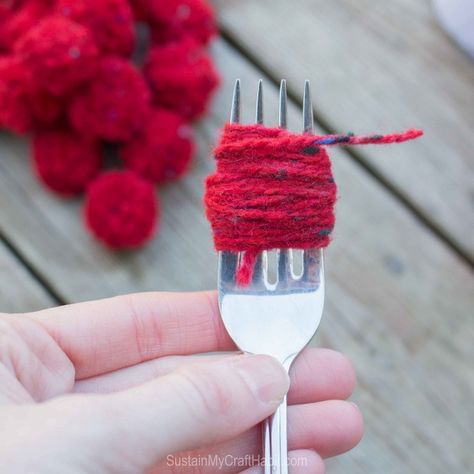 Red yarn would around a fork to create a DIY pom pom garland #christmas-crafts #decor #driftwood-crafts #garland #mantel #mantle #pompoms #scrap-yarn #yarn #yarn-projects#christmas-crafts #knitting-and-crochet-patterns #valentines-day-drafts #sustainmycrafthabit Christmas Garland Diy Yarn, Yarn Decorations Christmas, Diy Christmas Gnome Garland Yarn, Pompom Garland Christmas Tree, Diy Wool Christmas Decor, Easy Yarn Christmas Ornaments, Diy Christmas Pom Pom Garland, Yarn Ball Garland, Christmas Yarn Garland Diy