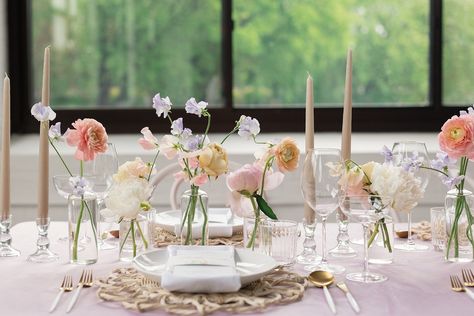 Delicate spring flowers in bud vases with taper candles Spring Wedding Inspiration at Urban Daisy | Denae Brennan Events Pastel Bud Vase Centerpiece, Spring Bud Vase Arrangements, Peach Bud Vases Wedding, Blush Candles Wedding, Spring Flowers Centerpiece, Bud Vases And Tall Candles, Wedding Florals Bud Vases, Bud Vases Taper Candles, Dainty Wedding Flowers Table