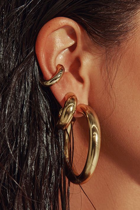 Any outfit, every day, all occasions. Sculpted in a two-inch arc, our 18K gold filled hoops are the style that unites true hoop girls and those who just dabble in the art. Wear solo or alongside other hoops in a graduating stack. Jewelry Collection Handcrafted in Brazil 18k Gold Filled Thickness: 7mm Diameter: 2" Weight: 0.55 oz Waterproof Hypoallergenic.#jewelrylover #handcraftedjewelry #jewelryinspiration #jewelrydesign #jewelryobsessed #jewelryoftheday #jewelrygoals #jewelryfashion #jewelrytrends Gold Hoop Earrings Aesthetic, Stack Jewelry, Chunky Gold Earrings, Chunky Gold Jewelry, Thick Gold Hoop Earrings, Thick Gold Hoops, Dope Jewelry Accessories, Thick Hoop Earrings, Multiple Ear Piercings