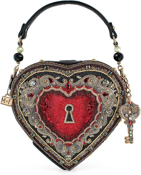 Mary Frances Embrace Top Handle Bag Spread love wherever you go with our heart-shaped locket handbag! Complete with a removable key charm and intricate filigree design, this top-handle bag is the perfect accessory for any occasion. DIMENSIONS: 8.5 x 2.25 x 8", Strap Length: 16.25", Strap Drop: 5.5", FEATURES: Non-removable top-handle, magnet closure, inside pocket, fits a phone, vegan leather THIS IS A HANDMADE ITEM, EACH ONE AN INDIVIDUAL WORK OF ART. SLIGHT VARIATIONS MAY OCCUR. I am a authorized retailer for Mary Frances Handbags  Must be returned as received in new condition as received with all the tags and wrappings ....Thank you   Enjoy and please leave me some great feedback! Mary Frances Handbags, Novelty Handbags, Novelty Purses, Big Handbags, Mary Frances, Purse Brands, Key Bag, Novelty Bags, Best Handbags