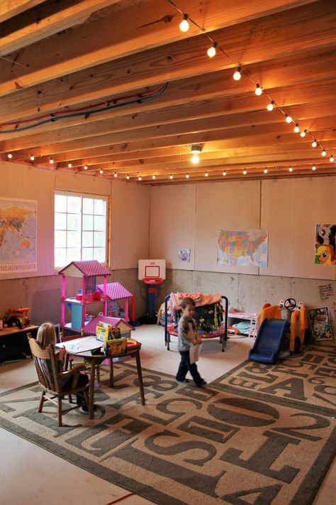 basement play room string lights kid cave unfinished basement kid toys storage and organization Unfinished Basement Playroom, Unfinished Basement Ceiling, Room String Lights, Basement Decoration, Basement Gym, Basement Playroom, Cozy Basement, Diy Basement, Basement Storage