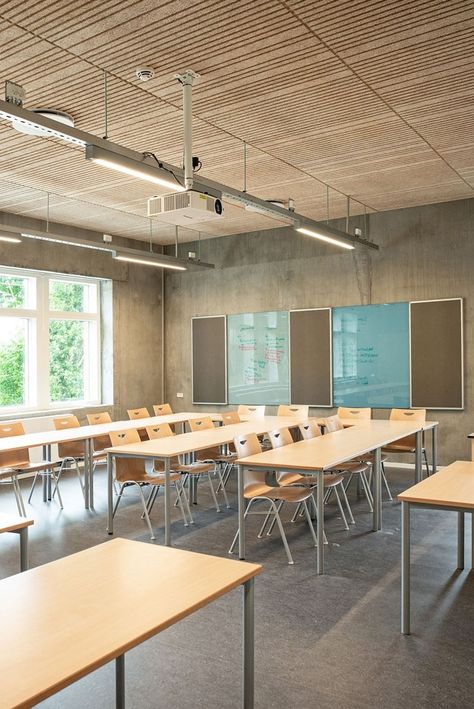 Acoustic ceiling panels in the design solution Troldtekt line are used throughout this school building. The dynamic feel of the ceiling and the wood colour contrast beautifully with the concrete, and the precision of the lines and the varying patterns are also ideally suited to counterbalance the raw walls. #goodacoustics #holzwolleplatten #träullsplattor #acousticpanels | Architects: Mangor & Nagel arkitekter Classroom Lighting Design, School Ceiling Design, Scandinavian Classroom, Classroom Wall Design, School Interior Design Classroom, Interior Design Classroom, School Classroom Design, Classroom Interior Design, Schools Interior