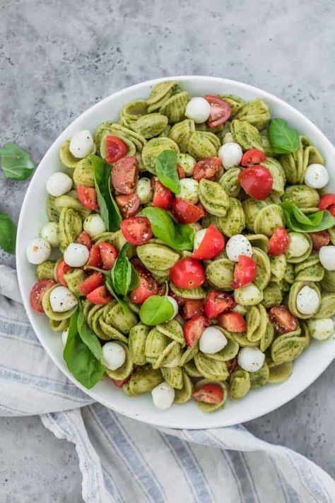 Caprese Pasta Salad. The ultimate summer potluck dish, it's made with chunks of pearl mozzarella, juicy grape tomatoes and tossed in a bright pesto sauce! | Pasta Salad | Pesto Recipes | Caprese Salad | #pasta #salad #pesto #potluck #feelgoodfoodie Potluck Sides, Pasta Salad With Pesto, Summer Potluck Dishes, Pesto Food, Pesto Recipes, Resep Pasta, Sommer Mad, Caprese Pasta Salad, Summer Potluck