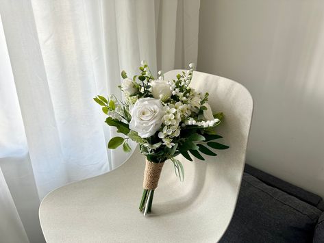 "Petite White Rose Wedding Bouquet 10\"/ Mini Hand-tied White Rose & Eucalyptus Bouquet/ Classic Small White Rose Greenery Bouquet/ Small Simple Wedding Bouquet/ Tiny Rustic Wedding Bouquet Petite white rose wedding boquet, which is classic and elegant.  Best choice for a simple and romatic wedding ceremony. Bridal bouquet at size 10 inches width. Bridesmaid bouquet at 6 inches width. I am using the top quality silk flower and eucalyptus on my work, that the bouquet looks very realistic and stunning.  Coordinating boutonnieres and corsages are available. If you need any matching archway, swag and tieback, garland, cake topper, centerpieces or hairpieces, please message me for a quote. Tailor made service are available, please send me your ideas for a quote. Jump to my shop here:  https://w Affordable Bridesmaid Bouquet, Small White Roses Bouquet, Mini White Rose Bouquet, Small Green Bouquet, Courthouse Wedding Bouquet Simple, White And Green Winter Wedding Bouquet, 3 Flower Bouquet Simple, Bride Bouquet White Elegant Simple, March Bridal Bouquet