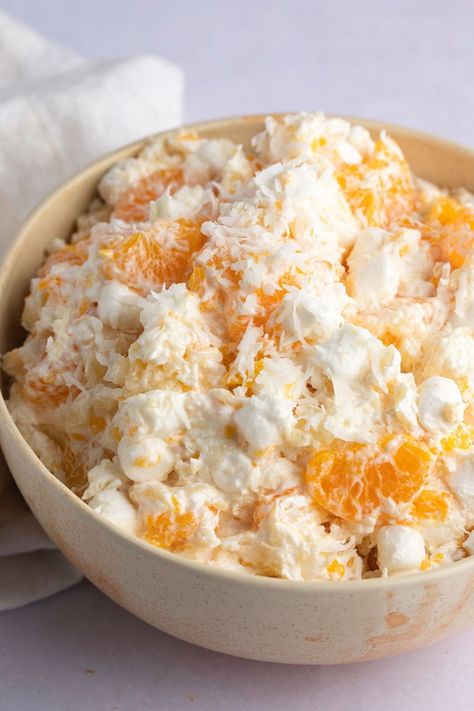 Ambrosia salad is super easy to make and always a hit at family gatherings. This creamy delight contains crushed pineapple, mandarin oranges, whipped topping, marshmallows, and shredded coconut. Recipe With Cool Whip, Salad With Mandarin Oranges, Frog Eye Salad, Recipes With Cool Whip, Ambrosia Recipe, Fruit Salad With Marshmallows, Ambrosia Fruit Salad, Best Fruit Salad, Fruit Salad Recipe