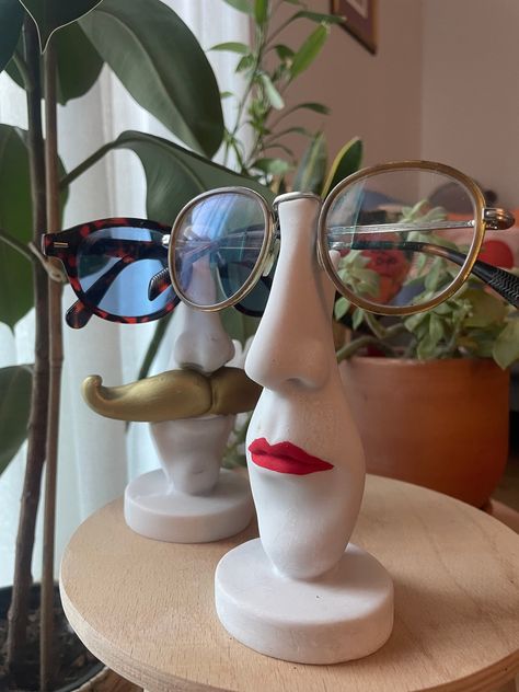 "Handmade Decor  Red lipstick If you're looking for the ideal gift for anyone obsessed with fun and organization, this desk top glasses holder is for you! A great way to keep your glasses organized and bring your smile at the same time.\" This funny and stylish glasses stand adds organization to your tabletop with a fun touch. Both personalized and functional, this product can be the perfect gift for friends or family who love order. The glasses holder made of stone material is durable and long- Mug With Face Ceramics, Clay Lipstick Holder, Pottery Glasses Holder, Clay Glasses Holder Diy, Air Dry Clay Glasses Holder, Ceramic Glasses Holder, Glasses Holder Clay, Mother Gifts Ideas, Clay Glasses Holder