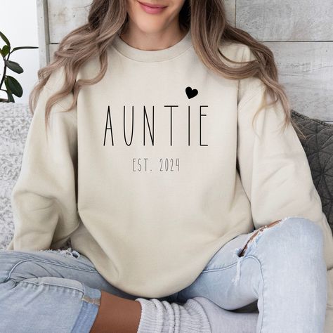 This auntie sweatshirt is perfect as a pregnancy announcement. It also makes a cute aunt gift. ♥ PRODUCTION TIME: 1-5 days (Usually 2-3 days) ♥ SHIPPING TIME: 2-5 days (Usually 3 days) ♥ PRODUCT DESCRIPTION: Gildan Unisex Sweater Feels cozy and excellent quality print makes. 50% cotton and 50% polyester Medium-heavy fabric (8.0 oz/yd² (271.25 g/m Runs true to size Our Relaxed Fit sweater (Gildan 18000) is a unisex style that runs a touch small for men, and about a half a size large for women. It's a relaxed fit and is soft and cozy. * For sweatshirt sizes please refer to the listing image. ♥ CARE INSTRUCTION: Machine wash: cold (max 30C or 90F) Non-chlorine: bleach as needed Tumble dry: low heat Do not iron Do not dryclean Turn inside out ♥ PRINTING METHOD: DTG printing method is used for Pregnancy Announcement Aunt, Being An Aunt, Pregnancy Announcement Family, Aunt Sweatshirt, Cool Aunt, Cricut Baby, Gifts For Aunt, Auntie Gifts, Aunt Gifts