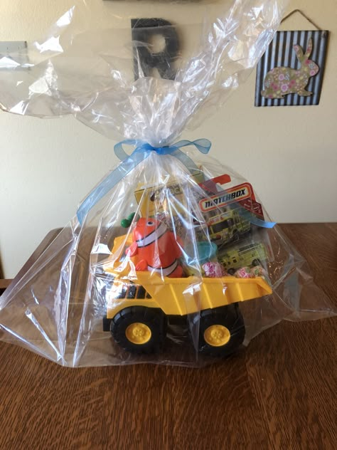 Toddler boy gift basket. Dump truck filled with toys, cars, cookies, play doh, and lollipops. Clear gift bag from dollar tree tied with a ribbon. Toddler Gift Basket, Car Gift Basket, Cars Cookies, Dollar Tree Birthday, Cadeau Man, Toy Gift Basket, Boy Gift Basket, Theme Baskets, Dollar Tree Gifts