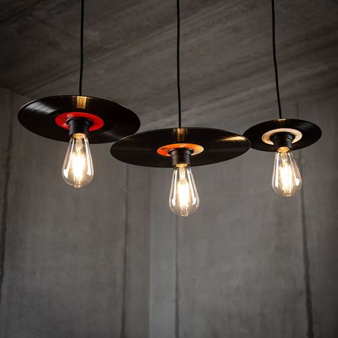 Elevate your space with a nostalgic touch and stylish ambiance by investing in our Retro Vinyl Record Lamp Pendant Set in a sleek black finish. Crafted from upcycled vinyl records, each lamp within the set is a unique piece of art, ensuring a distinct character for your lighting arrangement. 🎵💡 Available in versatile sets: - Set of 3 in 7-inch single size - Set of 3 in 10-inch EP size - Set of 3 in 12-inch LP size - Mix and match with a set featuring one of each size Handcrafted from authentic upcycled vinyl records, each lamp boasts individuality and may exhibit a variety of colors due to the upcycling process. The elegant black finish provides a modern and timeless aesthetic that complements various interior styles. Bulbs not included, offering you the flexibility to tailor the lightin Vinyl Record Ceiling, Custom Lighting Design, Record Upcycle Diy, Unique House Furniture, Music Bar Design, Retro Lamps Vintage, Record Lamp, Artistic Lamps, Alternative Lighting