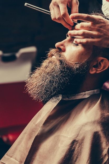 Bearded man with long beard getting hair... | Premium Photo #Freepik #photo #shave #barber-man #barber #barber-chair Barber Portrait, Barber Pictures, Barber Shop Pictures, Barber Ideas, Salon For Men, Barba Grande, Cut Pic, Barber Shave, Beard Barber