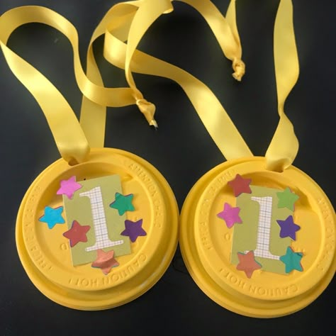 Painted plastic coffee cup lids can be decorated and made into kids' award medals. Run a ribbon through the opening and let the competition begin. Coffee Cup Lid Crafts, Diy Medals For Kids, Diy Medals, Olympic Medal Craft, Medal Craft, Trophy Craft, Diy Trophy, Plastic Coffee Cup, Olympic Crafts