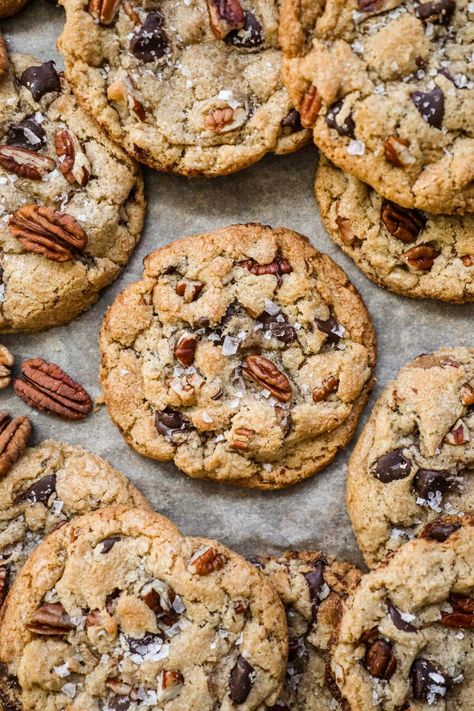 Brown Butter Pecan Chocolate Chip Cookies have a crispy-chewy texture, the irresistible crunch of pecans, and the rich sweetness of chocolate chips. Made with toasty brown butter for a touch of warmth, these cookies are topped with a sprinkle of flaky sea salt, elevating their flavor to new heights. Brown Butter Pecan White Chocolate Chunk Cookie, Carmel Pecan Chocolate Chip Cookie, Brown Butter Pecan White Chocolate Chunk, Cookie Recipes Pecan, Brown Butter Chocolate Chip Pecan Cookies, Cookie Recipes Chocolate Chip Brown Butter, Chocolate Chip Molasses Cookies, Butter Pecan Chocolate Chip Cookies, Pioneer Woman Chocolate Toffee Crunch Cookies