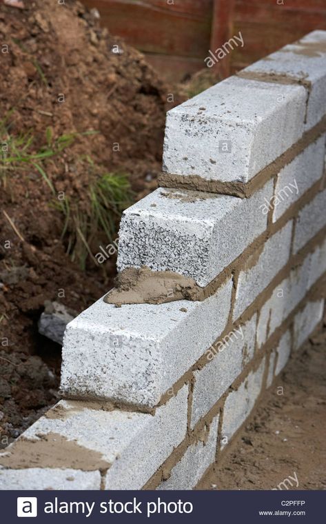 Download this stock image: bricklaying wall with half cement breeze blocks building a block retaining wall in the uk - C2PFFP from Alamy's library of millions of high resolution stock photos, illustrations and vectors. Block Retaining Wall, Breeze Block Wall, Retaining Wall Blocks, Breeze Blocks, Uk Images, Block Wall, Retaining Wall, Cement, About Uk