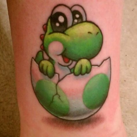 My baby yoshi tattoo by matt brumelow who does fantastic video game tattoos Small Yoshi Tattoo, Yoshi Tattoos, Yoshi Tattoo, Yoshi Drawing, Super Mario Tattoo, Video Game Tattoos, Mario Tattoo, Underboob Tattoo Designs, Video Game Tattoo