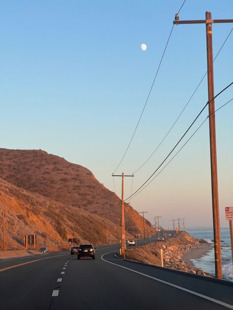 pacific coast highway on a curve around an amber mountain at sunset with moon visible in the still-blue sky just beyond the telephone wires, ocean tide coming in toward the rocky beach off to the right Pacific Highway California, California Cool Aesthetic, Highway One California, Norcal Beach Aesthetic, Y2k California Aesthetic, Rural California Aesthetic, Sonoma California Aesthetic, Pacific Coast Aesthetic, California Valley Aesthetic