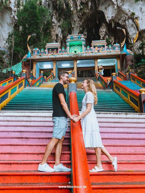 A couple looks at each other while standing on the colorful stairs of the Batu Caves in Kuala Lumpur Kl Tower, Malaysia Resorts, Singapore Vacation, Kuala Lumpur Travel, Malaysia Tour, Petronas Twin Towers, Kuala Lumpur City, Batu Caves, Malaysia Travel