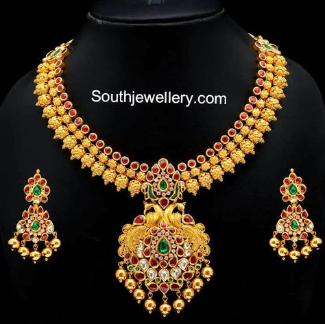 22 carat gold beautiful gold necklace with peacock design pendant studded with rubies, kundans, emeralds and diamonds. The necklace is complemented by matching beautiful earrings. Weight: 166 grams Price: Rs. 5,47,000 approx. For inquiries contact: info@vummidi.com Related PostsLight Weight Ruby South Sea Pearl NecklaceElaborate Kundan NecklaceElegant Gold NecklaceFancy Kundan NecklacePeacock Mango Pacchi Haram and JhumkasGold Latest Jewellery Designs, Jewel Design, Gold Necklace Indian, Antique Pins, Gold Jewelry Simple Necklace, Beautiful Gold Necklaces, Gold Necklace Indian Bridal Jewelry, Necklace Indian, Jewelry Photoshoot