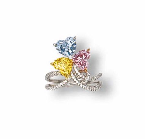 A COLOURED DIAMOND AND DIAMOND RING    Set with heart-shaped fancy intense blue, fancy vivid yellow and fancy intense purplish pink diamonds weighing 1.06, 0.91 and 0.88 carats to the diamond bifurcated shoulders, mounted in 18k white, pink and yellow gold Fancy Color Diamond Ring, Heart Shaped Diamond Ring, Fancy Diamond Ring, Colored Diamond Jewelry, Diamond Rings With Price, Colored Diamond Rings, Pink Diamonds, Diamond Ring Set, Unique Diamond Rings