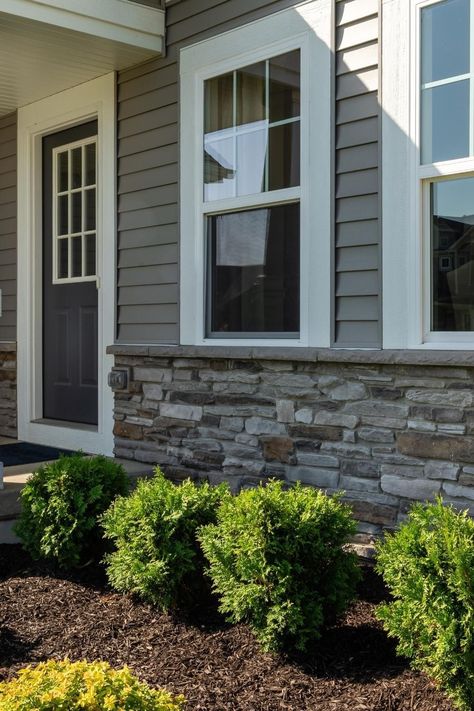 Elevate your home's exterior with stunning Dutch Quality Prestige Ledgestone. Our Dutch Quality® veneer is the perfect way to upgrade your home's exterior with stylish stone and siding combinations. Add pride and precision to your grey home exterior with a stunning stone veneer. At Instone, we've got you covered. Click this Pin to learn more today. Siding Stone Exterior, White House With Grey Stone, Exterior Vinyl Siding Ideas, Stone Exterior Ranch Style Home, Vinyl Siding With Stone Accent, Grey Home Exterior With Stone, Faux Rock Siding Exterior, Rock Front House Exterior, Exterior Siding Combinations