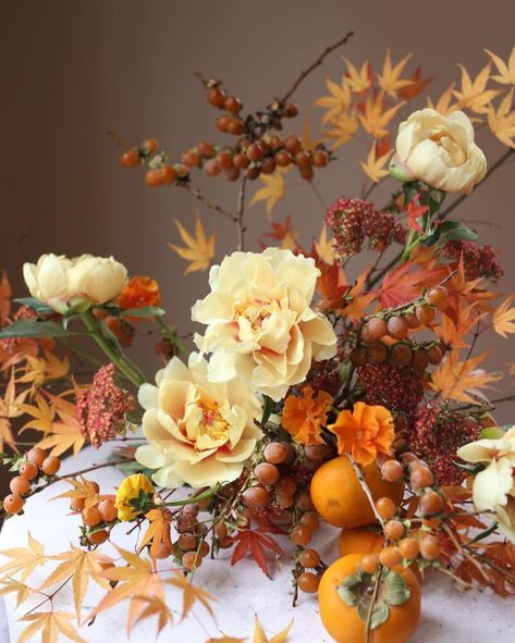 Leave it to abstract floral designs to stop us in our tracks. Whether they are weird and wild for their sculptural shapes, unexpected ingredients, bold color combos or dynamic textures, they sure do inspire the senses every time! Persimmon Floral Arrangement, Fall Flower Arrangements Wedding Autumn Centerpiece Ideas, Persimmon Arrangement, Autumn Wedding Flowers Centerpieces, Persimmon Aesthetic, Fall Floral Arrangements Centerpiece, Orange Arrangements, Fall Arrangements Floral Design, Orange Floral Arrangements