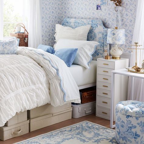 Add an enchanting feel to your space with this blue wallpaper, featuring a charming floral and lattice bow pattern. A peel-and-stick backing makes it simple to hang, and it has a convenient wipe-clean finish. Designed exclusively for Pottery Barn Teen by lifestyle brand LoveShackFancy. Made of digitally printed, non-woven wallcovering reinforced with synthetic fibers for strength and durability. Microsphere adhesive with removable paper backing. Adhesive is water activated. This is a one-time pe Blue Love Shack Fancy Bedroom, Blue Floral Dorm Room, Cute Bedroom Ideas Blue, White And Blue Dorm Room, Love Shack Fancy Dorm, Beach Bedroom Ideas For Teens, Blue Preppy Bedroom, Room Ideas Navy Blue, Pink And Blue Dorm