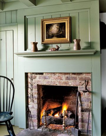 A sage green raised panel wall reveals a simple brick fireplace in this early-19th-century home. Antique pottery is displayed on the mantel. Country Fireplace, Cottage Fireplace, Mantel Ideas, Casas Coloniales, Colonial Decor, Home Fireplace, Cozy Fireplace, Brick Fireplace, Fireplace Mantel