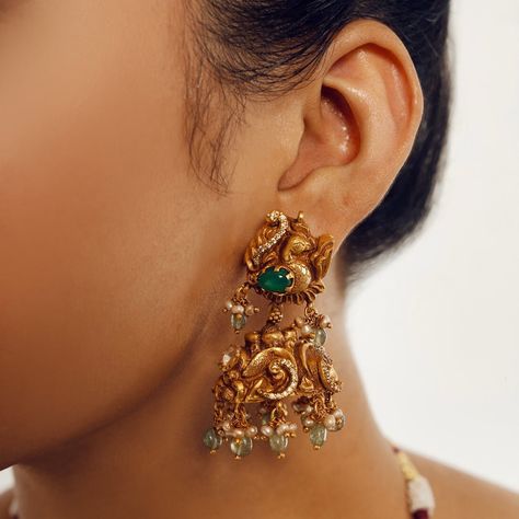 Introducing the Neema Emerald Mor Jhumkas by Yamoona--a perfect match to the Nakashi Short Necklace. These jhumkas showcase the same exquisite antique gold-plated design with intricate peacock detailing, moissanites, and emerald bead hanging stones. Elevate your style with these opulent jhumkas, capturing timeless elegance and heritage in gold plated workmanship. Gifting: This choker set comes in a beautiful Yamoona gift box, making it an ideal gift for birthday, wedding anniversary or wedding gift. Occasion: Perfect choice for any Indian occasion, festivals, parties, dances, and weddings Care: We recommend you protect your silver jewellery and increase the longetivity of the plating by placing the jewelry in a fabric pouch and storing it in a cool, dry place, keeping individual pieces sep Jhumkas Earrings, Pretty Jewelry Necklaces, Temple Jewelry, Silver Jewellery Indian, Emerald Bead, Jewelry Indian, Pretty Jewelry, Jhumka Earrings, Temple Jewellery