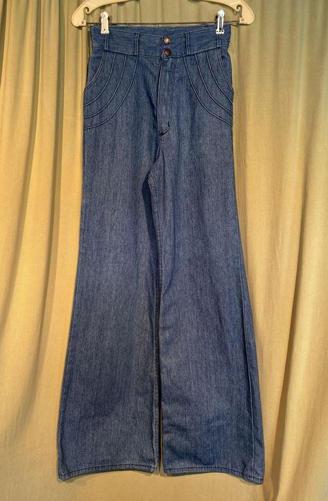 This is a pair of vintage jeans from the 70s. Labeled, Wrangler they are a labeled a size 9/10. Waist 26" Inseam 32", please see measurements below.  Made of blue cotton denim in a medium wash. The pants are high waisted with a double metal snap on the waistband. Metal zipper. The front hip pockets are trimmed with a raised welt design & the patch pockets on the seat have the same welt design. The legs are wide and bell bottoms.   The pants are in good condition. They show minimal wear and no soil. Edges of the legs are not frayed or worn. Measurements were taken with the garment lying flat. if you have never worn vintage before, please measure yourself or a pair of jeans that fit you well. Vintage sizes run smaller than today's sizes.  If you have any questions about measuring, please con 60s Clothing, 70s Pants, 70s Jeans, Extra Fashion, Jean Vintage, Jeans High Waist, Bottom Jeans, Fire Fits, Older Fashion