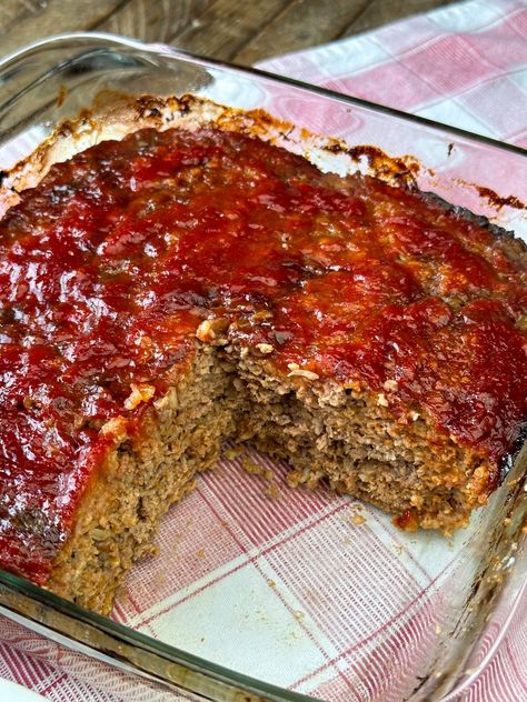 A mostly pan full of ketchup and brown sugar glazed meatloaf showing a moist, meaty filling with oats baked in a glass baking dish. Meatloaf In A Pan, Meatloaf In Cake Pan, 3lb Meatloaf Recipe, Meatloaf Made With Oats, Restaurant Meatloaf Recipes, Main Dish Meat Recipes, Cast Iron Meatloaf, Meatloaf Recipes Stove Top Stuffing, Loaf Pan Recipes Dinners