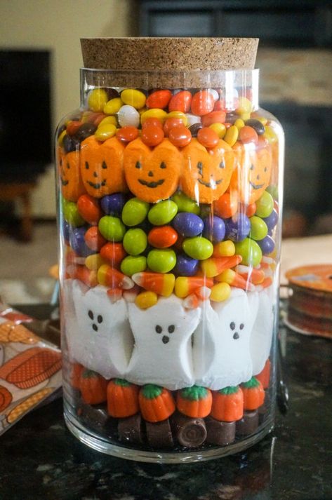 A Halloween Candy Jar is a unique way to decorate for the spooky holiday using all your favorite pretty, colorful candies. There are so many interesting types of candy at Halloween so it's the perfect time of year to use your creativity to make this candy jar. | Fall Candy Jar | Halloween Candy Decor | Decorating with Candy | Halloween Home Decor | #Halloween #Fall #Candy #CandyCorn #Peeps Halloween Candy Crafts For Adults, Halloween Candy Jars Gift Ideas, Halloween Candy Centerpiece, Halloween Candy Jars Diy, Halloween Candy Jars Ideas, Fall Candy Jar Ideas, Candy Jars Ideas, Halloween Candy House, Halloween Candy Table Ideas